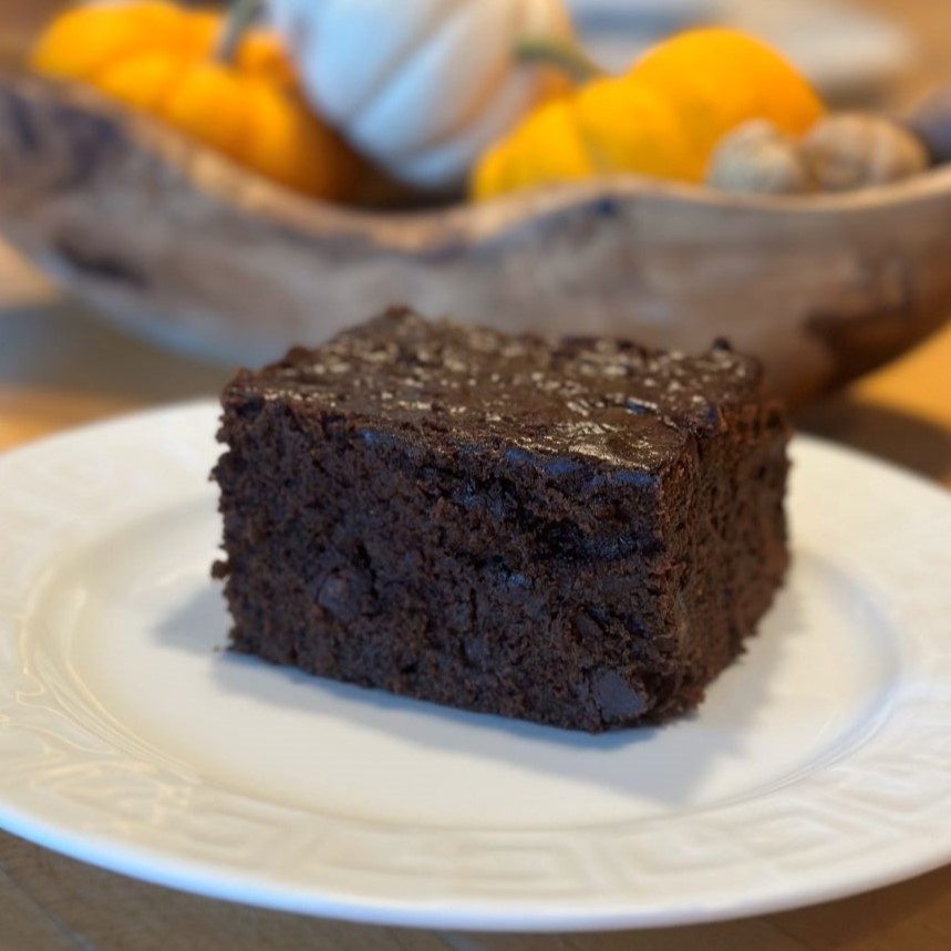 The Best Double Chocolate Zucchini Cake cover image, which includes a slice of cake on a white plate.