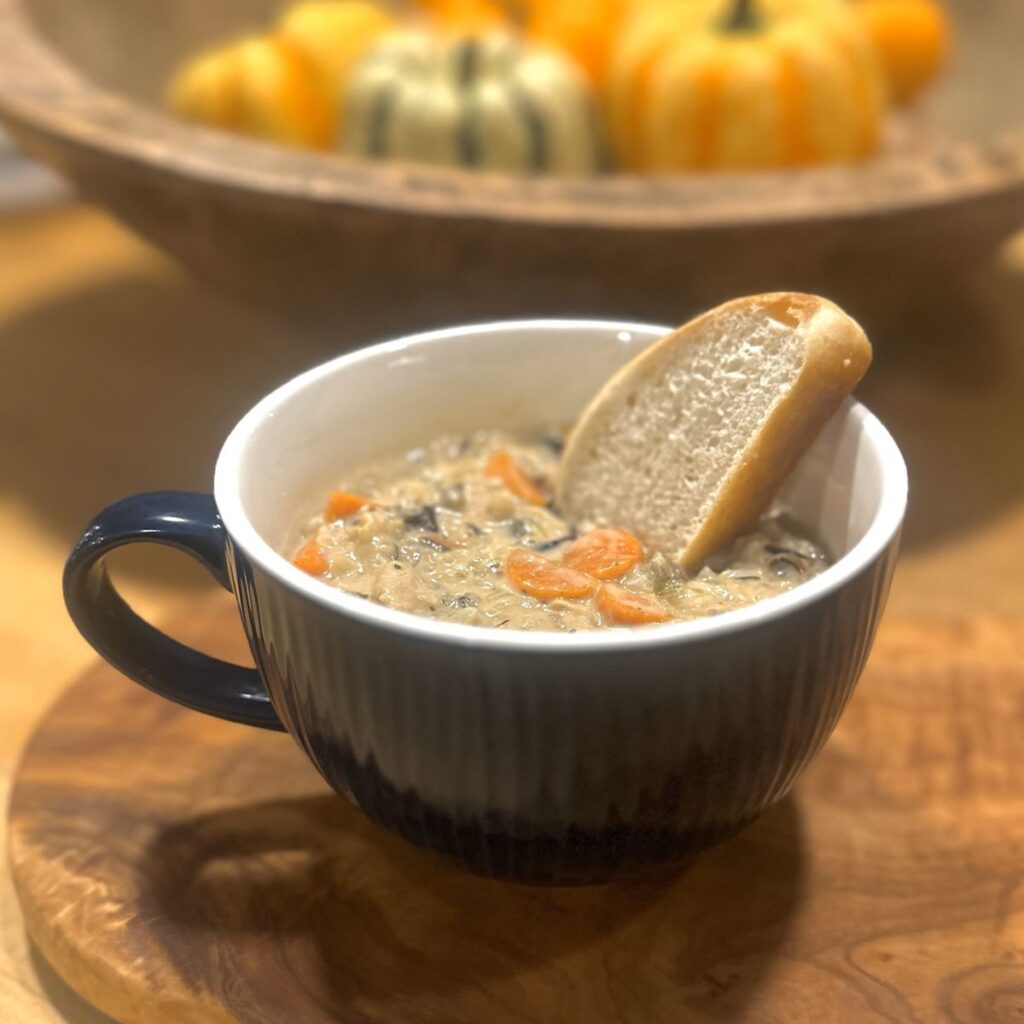 A bowl of chicken and wild rice soup sitting on the kitchen counter.