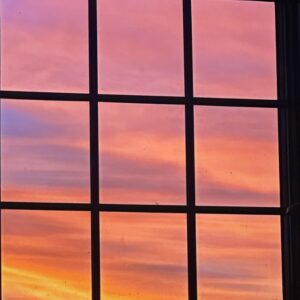An image of a beautiful sunset seen through a window.