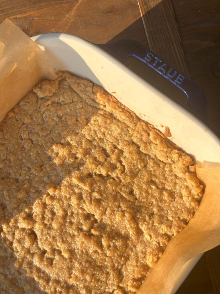Golden Brown Baked Oat Bars in a Navy Staub Baker