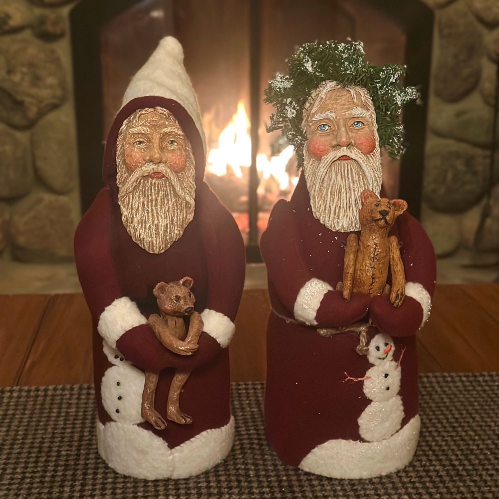 Two Burgundy Debra Schoch Santas With Bears in Front of the Fireplace