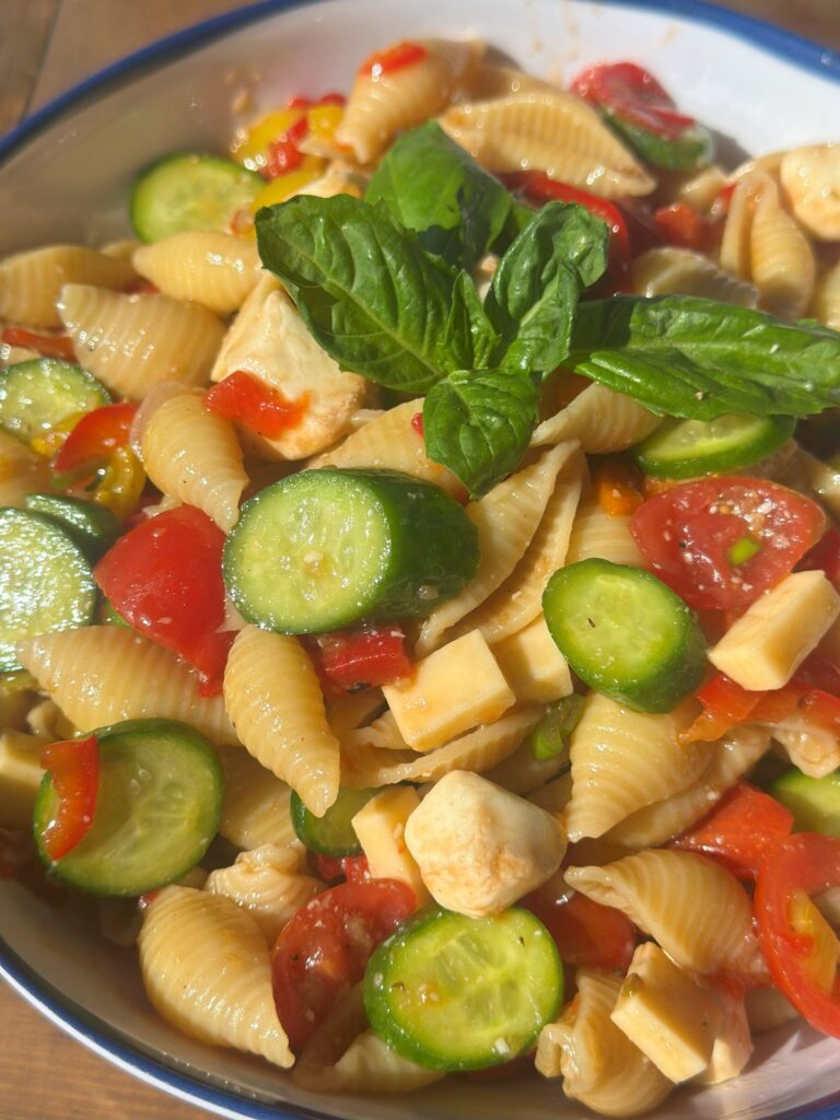 Easy Italian Pasta Salad Topped With Fresh Basil In a White Bowl