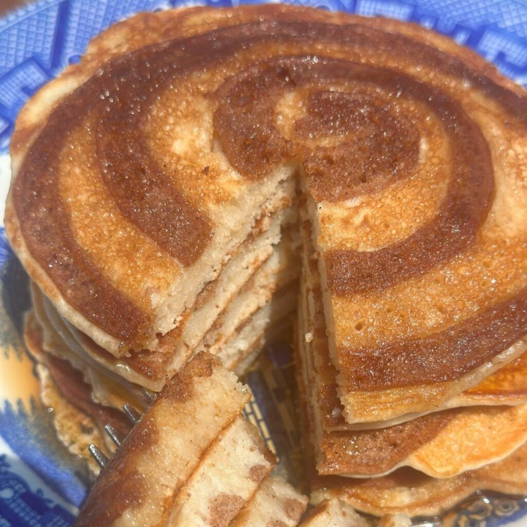Easy Cinnamon Swirl Pancakes Made With Pancake Mix On a Blue Willow Plate With a Slice Taken Out Sitting on a Fork