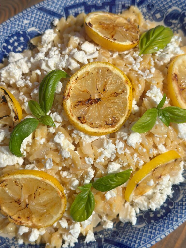 Creamy Lemon Orzo With Feta Close Up With Grilled Lemon Slices and Fresh Basil