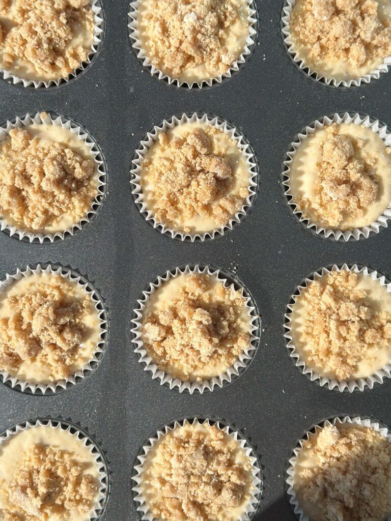 Banana Muffin Batter Scooped Into Tin With Streusel On Top