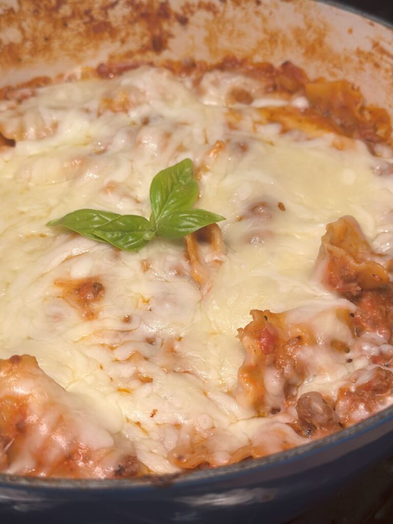 A close up of the skillet lasagna, featuring lots of gooey cheese and some fresh basil leaves.